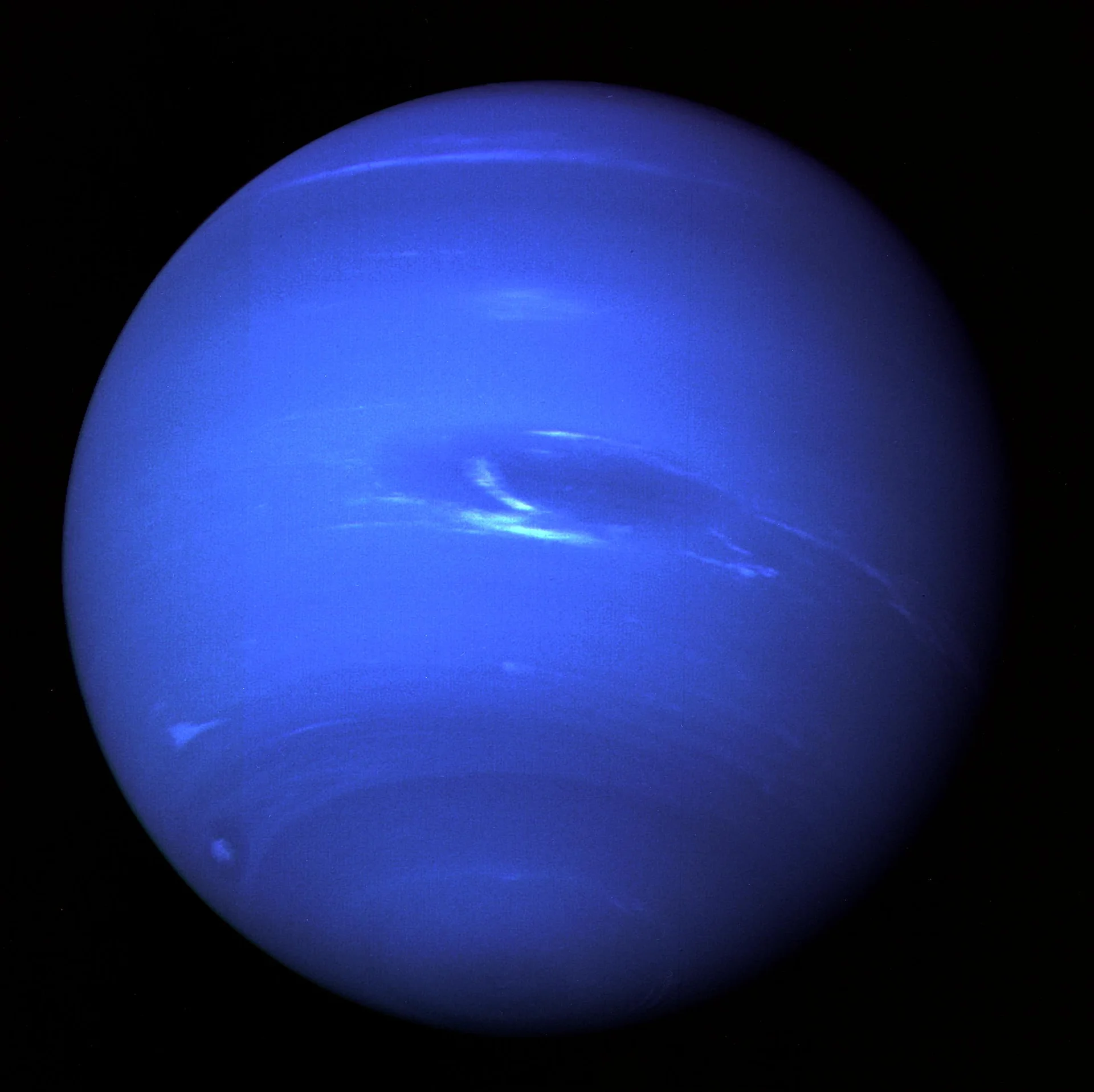 Full-disk view of Neptune taken by Voyager 2 in August 1989, showing the Great Dark Spot and its companion bright cloud, the fast-moving feature nicknamed Scooter, and bands of high-altitude cirrus